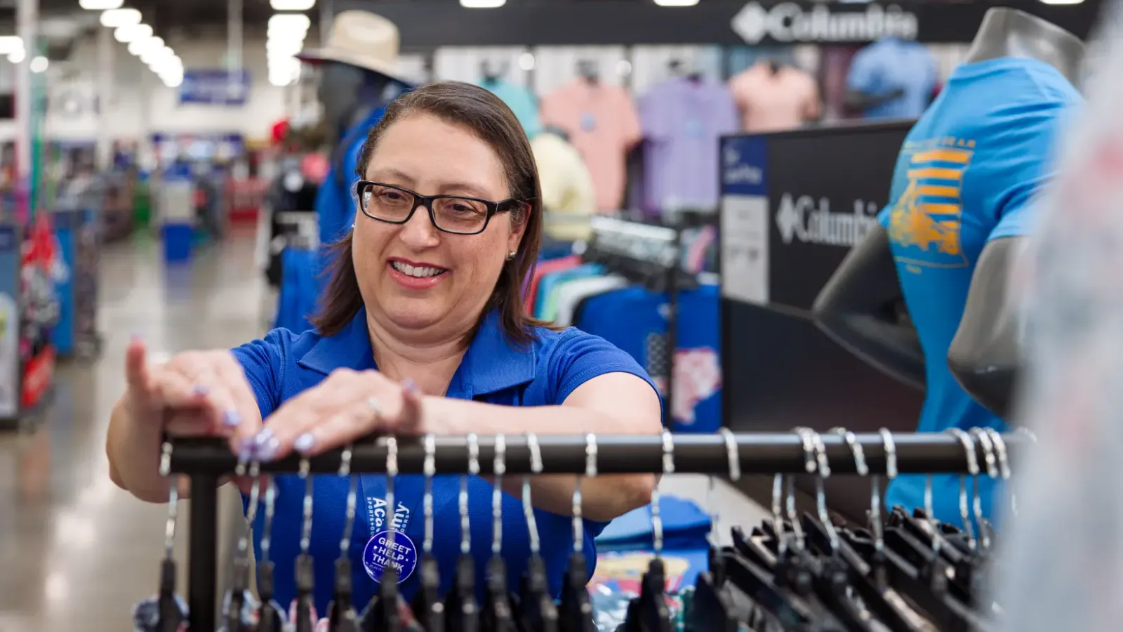 An Academy Sports & Outdoors associate merchandising the floor — the expertise the video captures