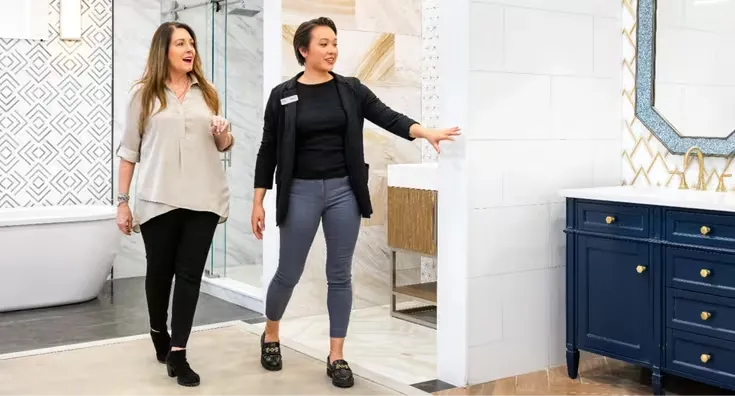 A designer walking a customer through a finished bathroom vignette